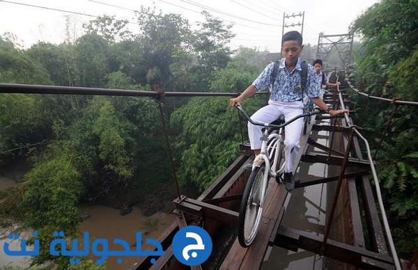 أطفال في إندونيسيا يعبرون جسراً خطيراً للذهاب إلى المدرسة